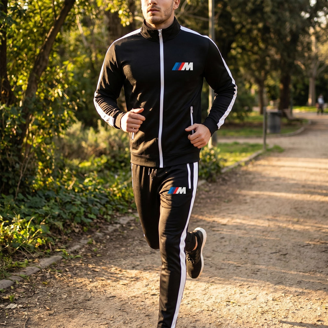 Male model jogging in BMW M Dri-Fit Track Suit along park path during late afternoon, showing breathability and outdoor versatility.