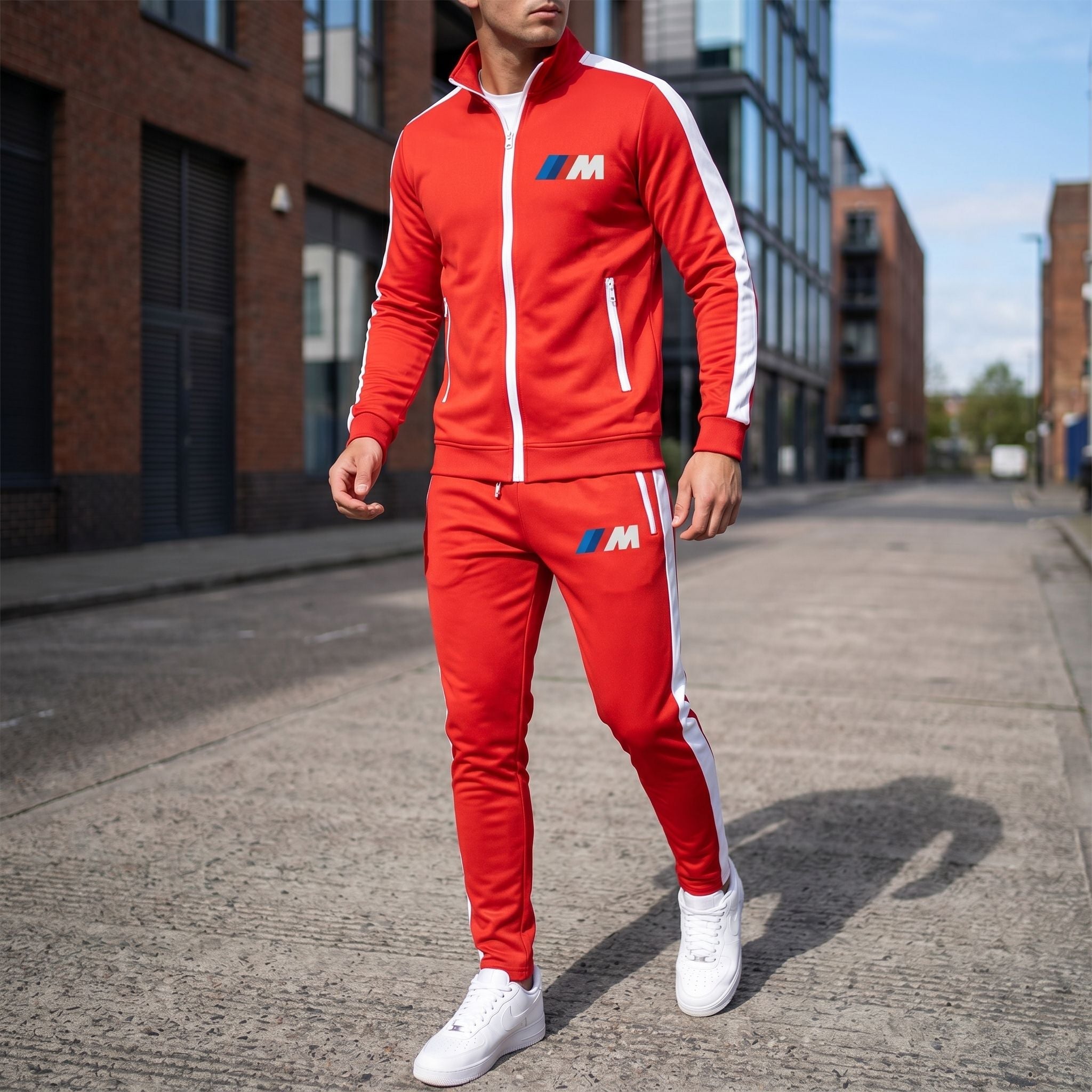 Full-body view of a man wearing black BMW M Dri-Fit TrackSuit on an urban street with cityscape background.